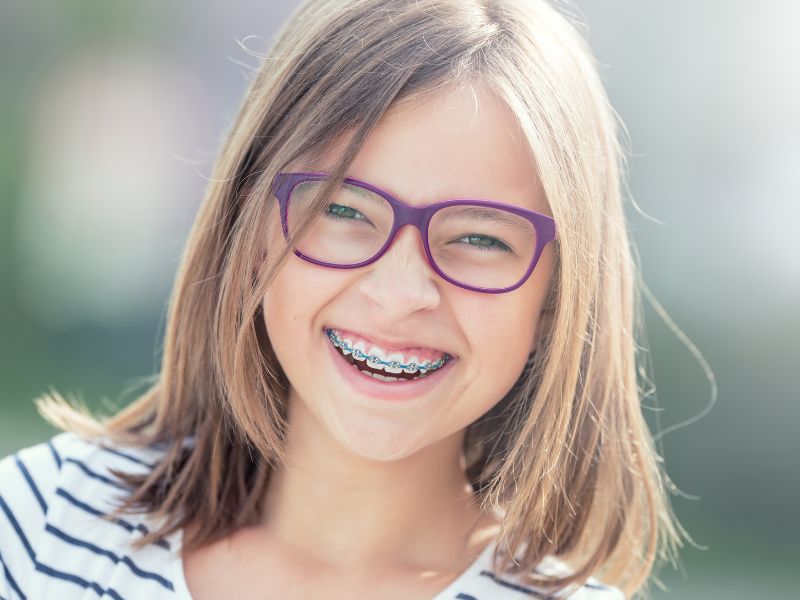 Child with metal braces and colorful bands at our office near Kissimmee