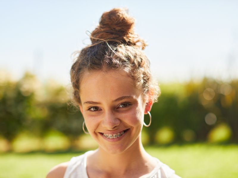 Teen patient smiling with braces from our orthodontist in Celebration FL