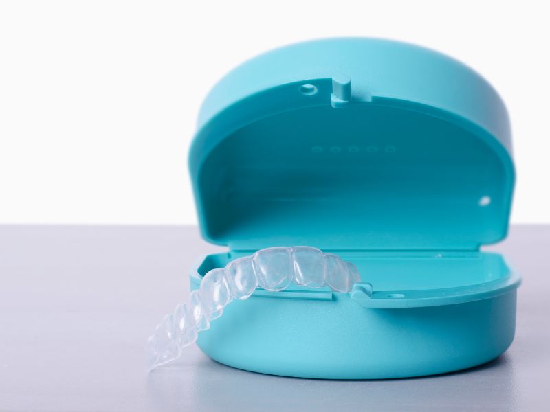 Clear retainer after braces resting in its case at our office near Kissimmee