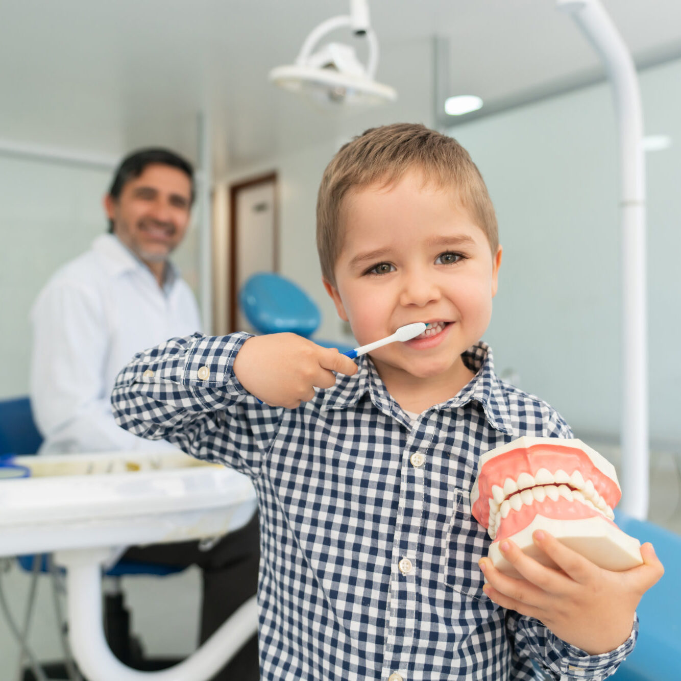 A baby first dental visit showing a gentle lap-to-lap infant oral exam with a board-certified pediatric dental provider